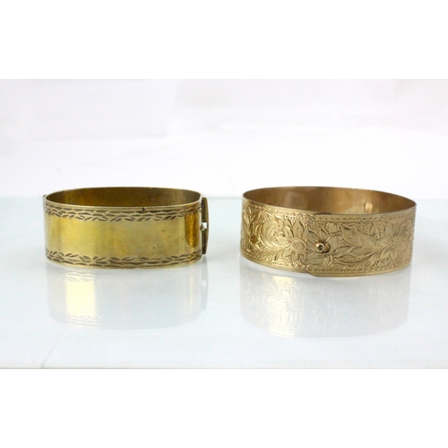 73 - A 20th century gold plated bangle, the florally engraved bangle with spherical hook fastening, 7.5cm... 