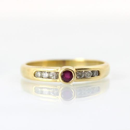 90 - A yellow metal untested ruby and diamond ring, the central round cut untested ruby within rub over s... 