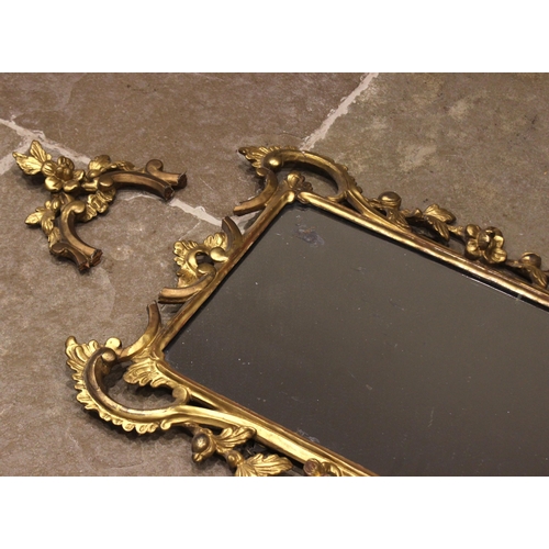 453 - A George III giltwood wall mirror, the rectangular mirrored plate set within a 'C' scroll and foliat... 