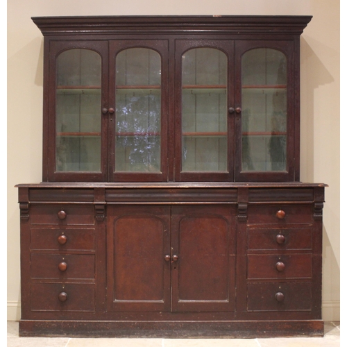 487 - A Victorian stained pine glazed bookcase/housekeepers cupboard, the moulded cornice over two pairs o... 