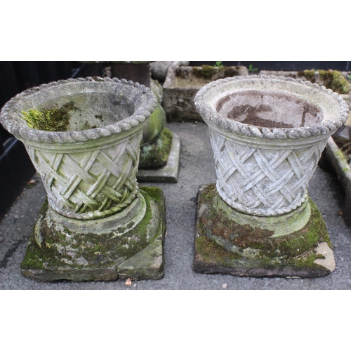 523 - A pair of reconstituted stone planters, of tapering trumpet form, moulded in relief with raised latt... 