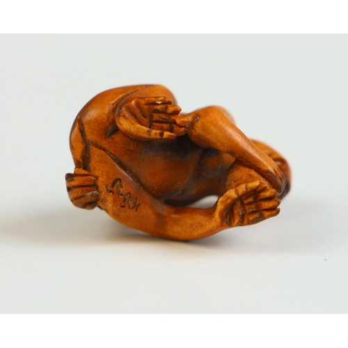 302 - A Japanese carved wood netsuke, Meiji Period (1868-1912), modelled as a seated monkey, holding a fru... 