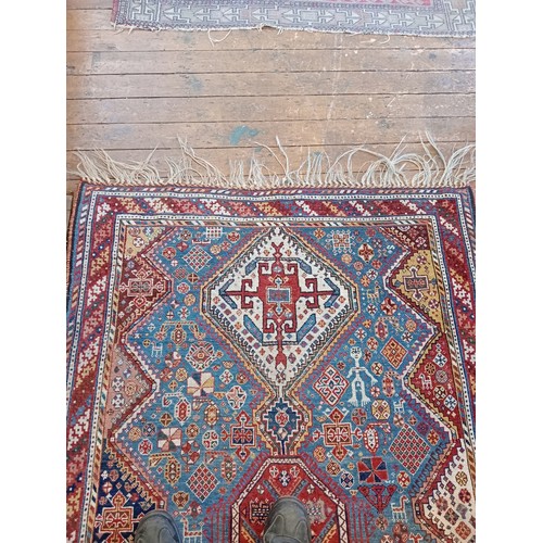 391 - A Persian Heriz type hand knotted wool rug, the central blue ground with three linked octagonal meda... 