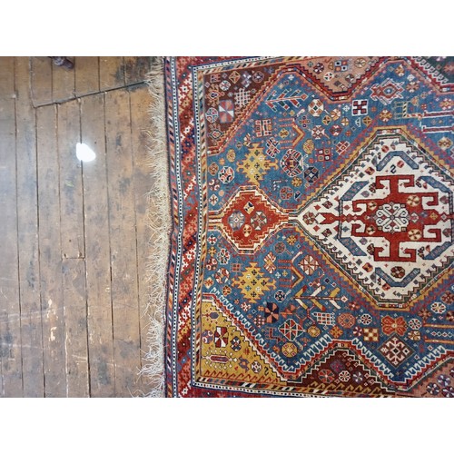 391 - A Persian Heriz type hand knotted wool rug, the central blue ground with three linked octagonal meda... 