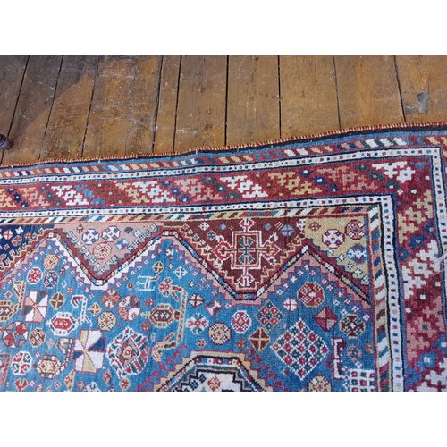 391 - A Persian Heriz type hand knotted wool rug, the central blue ground with three linked octagonal meda... 