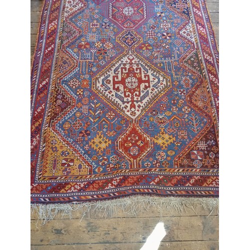 391 - A Persian Heriz type hand knotted wool rug, the central blue ground with three linked octagonal meda... 