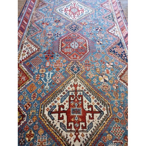 391 - A Persian Heriz type hand knotted wool rug, the central blue ground with three linked octagonal meda... 