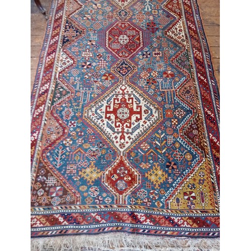 391 - A Persian Heriz type hand knotted wool rug, the central blue ground with three linked octagonal meda... 