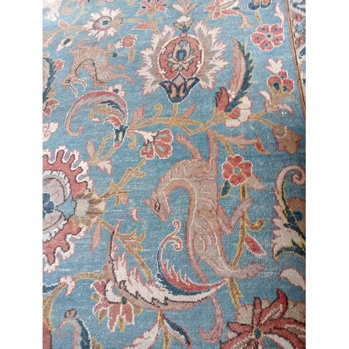 384 - A Persian Tabriz wool carpet, with an all-over traditional foliate and zoomorphic design against a b... 