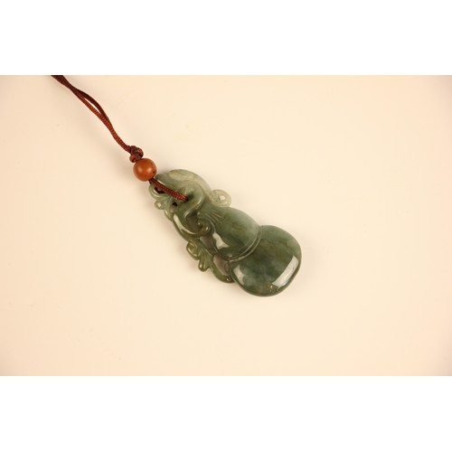 317 - A Chinese green 'jade' pendant, the carved pendant with dragon shaped detail, 6cm long, with a furth... 