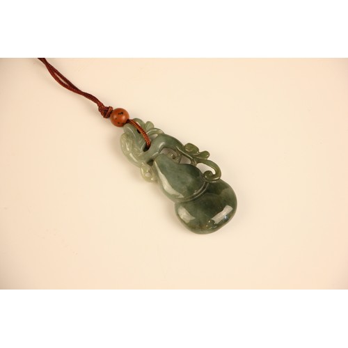 317 - A Chinese green 'jade' pendant, the carved pendant with dragon shaped detail, 6cm long, with a furth... 