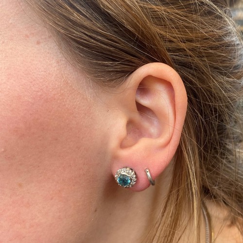 65 - A pair of blue zircon and diamond cluster earrings, the round cut blue zircons within a surround of ... 