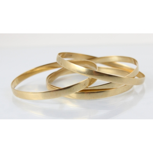 103 - A set of four South African yellow metal bangles, of plain polished form, stamped to interior ‘9ct’ ... 