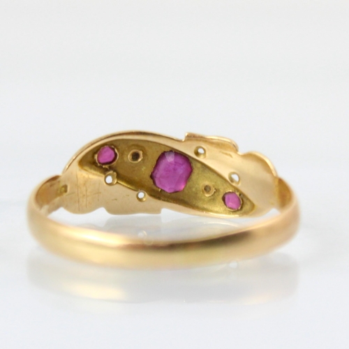 104 - An early 20th century yellow metal ring, the red stone set ring with rose cut diamond detail, set wi... 