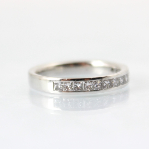 110 - A diamond half eternity ring, the fourteen princess cut diamonds channel set in white metal, with pl... 