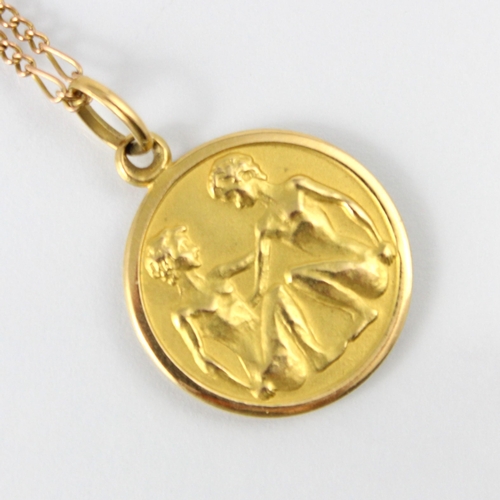 116 - A yellow metal ‘Gemini’ style pendant, the circular pendant stamped to reverse ‘750’ upon an associa... 