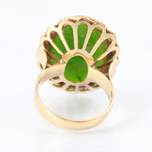 118 - A yellow metal nephrite dress ring, the oval shaped cabochon within a yellow metal bamboo style moun... 