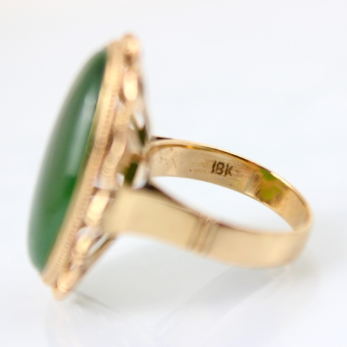 118 - A yellow metal nephrite dress ring, the oval shaped cabochon within a yellow metal bamboo style moun... 