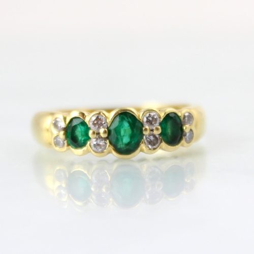 126 - A mid 20th century untested emerald and diamond ring, the central oval cut untested emerald with two... 