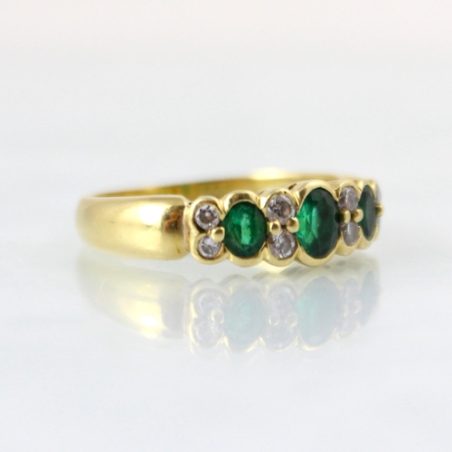 126 - A mid 20th century untested emerald and diamond ring, the central oval cut untested emerald with two... 