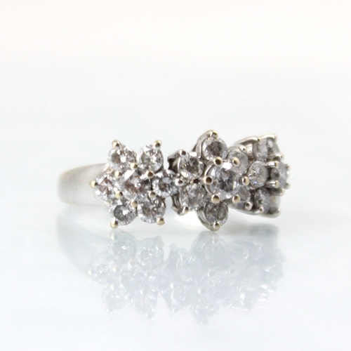 127 - A 18ct white gold diamond triple cluster ring, the central round cut diamond within surround of six ... 