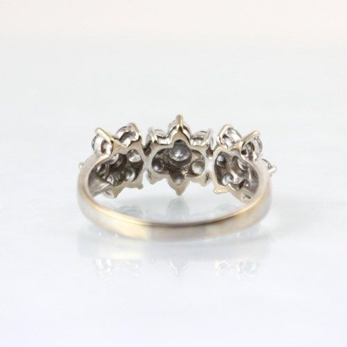 127 - A 18ct white gold diamond triple cluster ring, the central round cut diamond within surround of six ... 