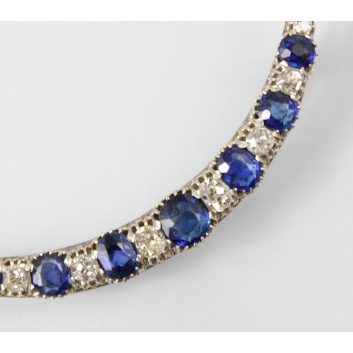 130 - An early 20th century diamond and untested sapphire crescent brooch, the seven graduated cushion cut... 