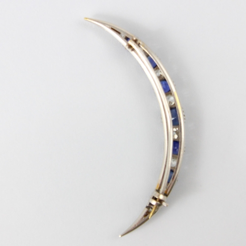 130 - An early 20th century diamond and untested sapphire crescent brooch, the seven graduated cushion cut... 