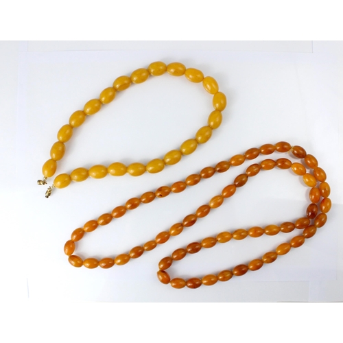 135 - A string of butterscotch coloured ‘amber’ beads, the twenty three oval beads with base metal screw f... 