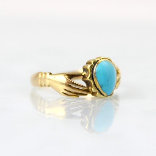 147 - A Regency style fede style ring, the central turquoise coloured cabochon clasped by two hands leadin... 