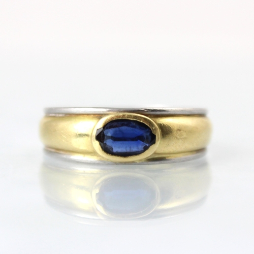 149 - An 18ct two tone gold and untested sapphire ring, the oval cut untested sapphire set 'East to West' ... 