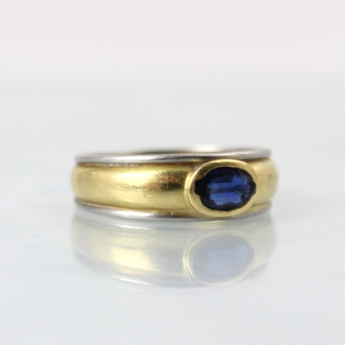 149 - An 18ct two tone gold and untested sapphire ring, the oval cut untested sapphire set 'East to West' ... 