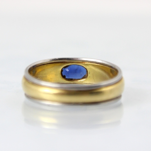 149 - An 18ct two tone gold and untested sapphire ring, the oval cut untested sapphire set 'East to West' ... 