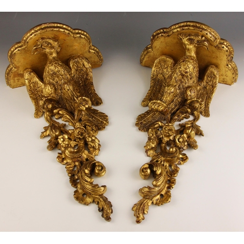 534 - A pair of George II style carved giltwood wall brackets, 19th century, each with a scalloped moulded... 