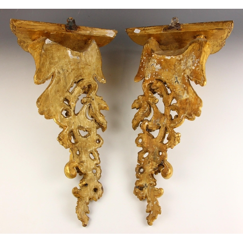 534 - A pair of George II style carved giltwood wall brackets, 19th century, each with a scalloped moulded... 