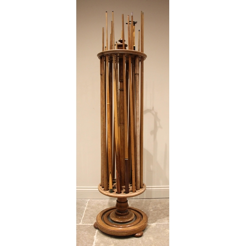 578 - A late Victorian oak revolving snooker cue stand, upon a moulded circular plinth base and compressed... 