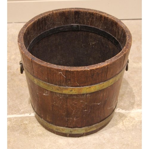 598 - A George III oak and brass bound coopered peat bucket, applied with side ring handles, lacking liner... 