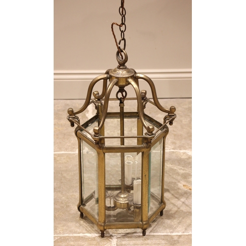 603 - An early 20th century brass hexagonal hall lantern, the central boss extending to six curved support... 