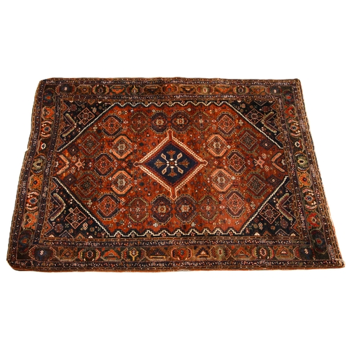 629 - A Persian hand knotted wool rug, the central blue medallion inset with a star shaped motif, upon a r... 