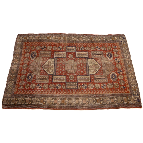 630 - A Turkish hand knotted village rug, the fragmented geometric design upon a central red field, confin... 