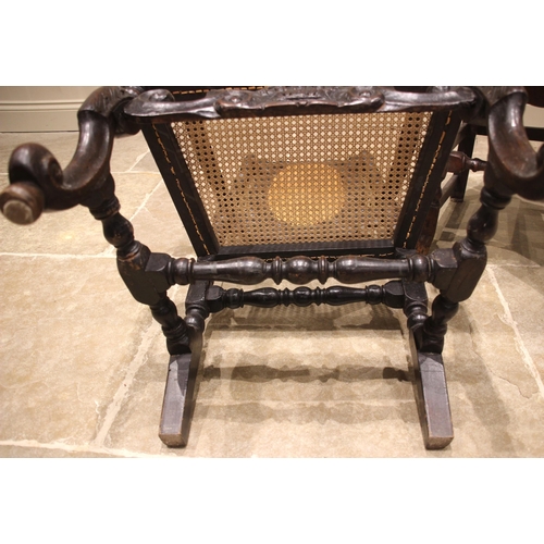 683 - A walnut Carolean open armchair, late 17th century, the high back with a carved coronet crest over t... 