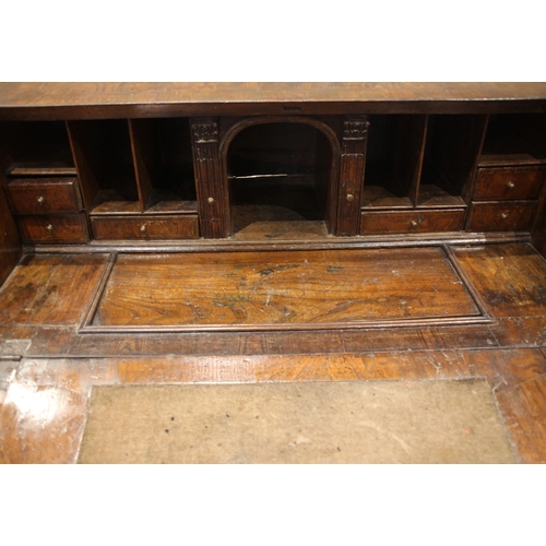 684 - A George II burr elm and oak bureau, the crossbanded and feather banded fall front opening to a cent... 