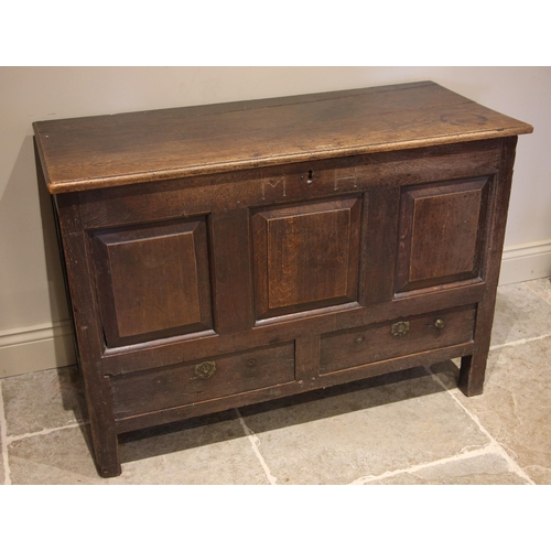 689 - An 18th century oak mule chest, the hinged plank top opening to a fitted candle box over three field... 