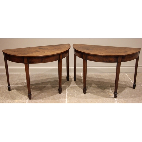 702 - A pair of George III mahogany D-end side tables, each with a plain frieze upon tapering legs of squa... 