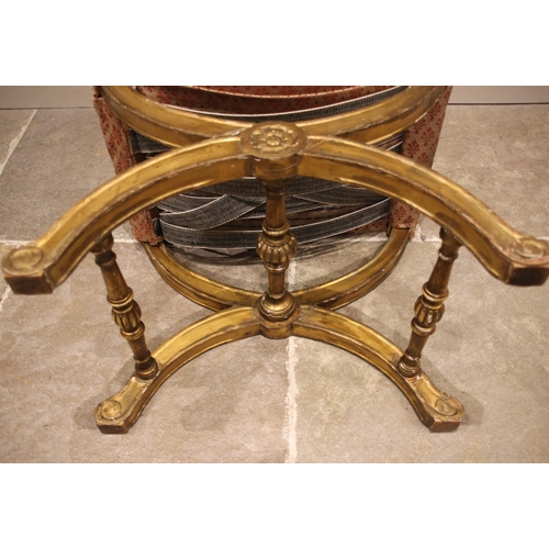 717 - A Regency giltwood and gesso 'X' form stool, the later upholstered seat cushion upon a moulded frame... 