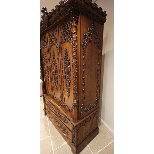 735 - A Scottish baronial oak hall cupboard, late 19th century, the castellated cornice and Gothic spire f... 