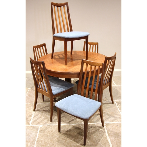 787 - A mid 20th century G Plan teak dining table with six chairs, the circular table with fold out leaf a... 