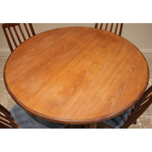 787 - A mid 20th century G Plan teak dining table with six chairs, the circular table with fold out leaf a... 