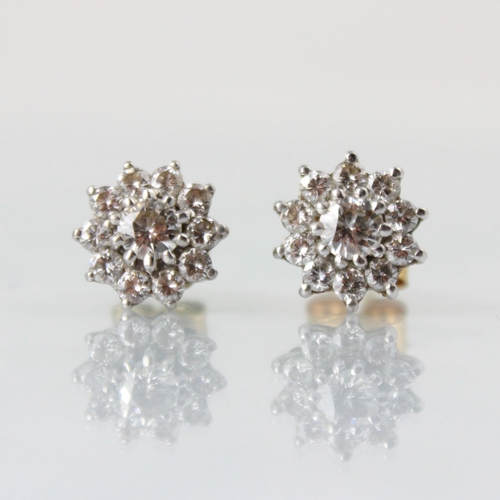 143 - A pair of diamond cluster earrings, the central round cut diamond within a surround of ten smaller r... 