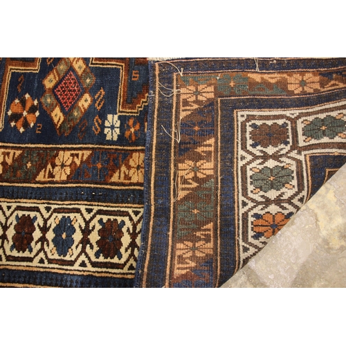 633 - An Iranian tribal village rug, in blue, rust and ivory colourways, the central geometric field withi... 